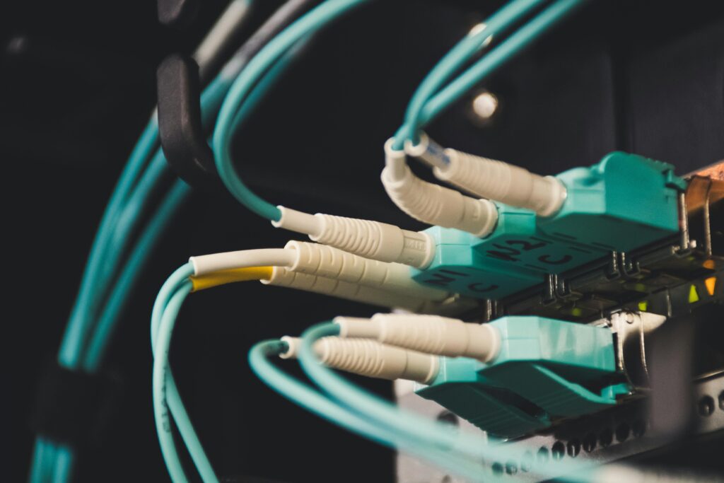 pexels-photo-1624895-1624895 Detailed view of fiber optic cables and ports in a server room, showcasing connectivity.